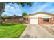 Front exterior of brick home with well-maintained lawn and driveway at 5175-5185 Simms Pl, Wheat Ridge, CO 80033