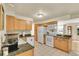 The kitchen features wooden cabinets, tile floors, and white appliances at 5175-5185 Simms Pl, Wheat Ridge, CO 80033