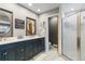 Bright bathroom featuring dual vanities, framed mirrors, and a glass-enclosed shower at 5300 Tabor St, Arvada, CO 80002