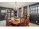 Elegant dining room features a dark accent wall with a chandelier and seating for eight at 5300 Tabor St, Arvada, CO 80002