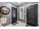 Home's entry way featuring dark doors, a round mirror, decorative flowers, and marble tile flooring at 5300 Tabor St, Arvada, CO 80002