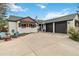 Home's exterior view showcasing the three-car garage, large driveway and well-kept garden with lawn furniture at 5300 Tabor St, Arvada, CO 80002