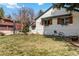 A lush front yard with a charming white brick house featuring wooden shutters and flower boxes at 5300 Tabor St, Arvada, CO 80002