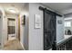 Hallway featuring a decorative sliding barn door and access to a bathroom at 5300 Tabor St, Arvada, CO 80002