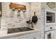The kitchen features a brick accent wall, modern black countertops and appliances, and a 