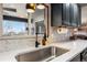 Kitchen sink area with white countertops, patterned backsplash, and a view of the backyard at 5300 Tabor St, Arvada, CO 80002