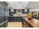 A spacious kitchen with black cabinetry, center island, hardwood floors, and stainless-steel appliances at 5300 Tabor St, Arvada, CO 80002