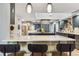 Spacious kitchen featuring dark cabinets, a central island with bar stools, and modern lighting at 5300 Tabor St, Arvada, CO 80002