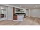 Entertainer's basement offers a stylish bar with shelving, black countertop, and sleek wood accents on wood floors at 7684 S Ingalls St, Littleton, CO 80128