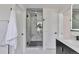 Elegant bathroom with a glass-enclosed shower, marble tile, and contemporary black fixtures at 7684 S Ingalls St, Littleton, CO 80128