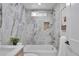 Stylish bathroom features a tub, luxe marble tiling, and decorative niche, creating a spa-like atmosphere at 7684 S Ingalls St, Littleton, CO 80128