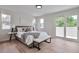Bright bedroom with natural light, hardwood floors, and a comfortable bed with stylish accents at 7684 S Ingalls St, Littleton, CO 80128