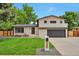 Charming two-story home with a well-manicured lawn and modern architectural details and a gray garage door at 7684 S Ingalls St, Littleton, CO 80128