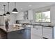 Modern kitchen featuring white cabinets, stainless steel appliances, a dark countertop, and stylish pendant lighting at 7684 S Ingalls St, Littleton, CO 80128