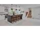 Open-concept kitchen with a large island, modern appliances, stylish bar stools, and access to the staircase at 7684 S Ingalls St, Littleton, CO 80128