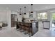 Modern kitchen with white cabinets, stainless steel appliances, a large island, and stylish pendant lighting at 7684 S Ingalls St, Littleton, CO 80128