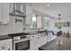 Bright, well-equipped kitchen with stainless steel appliances, a farmhouse sink, and sleek countertops at 7684 S Ingalls St, Littleton, CO 80128