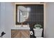 Chic powder room with a unique circular mirror, modern fixtures, and stylish accent wall at 7684 S Ingalls St, Littleton, CO 80128