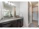 Bathroom featuring a glass door shower, a gray countertop, and a dark wood cabinet at 9051 E 61St Ave, Denver, CO 80238