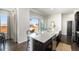 Open concept kitchen with a large island, stainless steel appliances, and dark wood floors at 9051 E 61St Ave, Denver, CO 80238