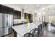 Modern kitchen with stainless steel appliances, a large center island, and stylish dark cabinetry at 9051 E 61St Ave, Denver, CO 80238