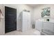 Functional laundry room with a white washer and dryer, ample storage and tile flooring at 9051 E 61St Ave, Denver, CO 80238