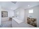 A bright, neutrally decorated loft featuring gray carpet, modern artwork, and a seating area near the window at 46559 Avery Ln, Bennett, CO 80102