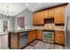 Bright kitchen features stainless steel appliances and wood cabinets at 14442 E 102Nd Pl, Commerce City, CO 80022