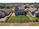 Aerial view of fenced backyard with lawn, patio with seating, and modern home design at 7414 Blue River Ave, Frederick, CO 80530