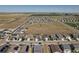 Planned community aerial showcasing homes with fenced yards near a vast open space and roadways at 7414 Blue River Ave, Frederick, CO 80530