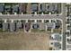 The aerial view displays a street lined with houses, showcasing their roofs, lawns, and the adjacent open field at 7414 Blue River Ave, Frederick, CO 80530