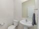 Clean half-bathroom with toilet, pedestal sink, towel bar, and a mirror at 7414 Blue River Ave, Frederick, CO 80530