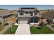 Charming two-story home with a well-maintained front yard, two-car garage, and solar panels on the roof at 7414 Blue River Ave, Frederick, CO 80530