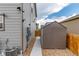 Side of house with storage shed, gravel landscaping, and utilities neatly organized at 7414 Blue River Ave, Frederick, CO 80530