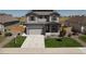 Charming two-story home with a well-kept lawn, two-car garage, and welcoming front porch seating at 7414 Blue River Ave, Frederick, CO 80530
