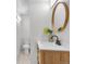 Modern bathroom features wood vanity, round mirror and natural light at 3619 N York St, Denver, CO 80205