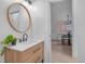 Bathroom vanity with modern faucet and round mirror, with a view to the dining area at 3619 N York St, Denver, CO 80205