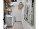Functional laundry room with modern washer and dryer, complemented by practical shelving and neutral tile flooring at 3619 N York St, Denver, CO 80205