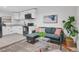 Stylish living area featuring modern sofa and decor next to a kitchen with white cabinetry and black appliances at 3619 N York St, Denver, CO 80205
