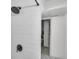 Modern shower featuring white subway tile and sleek, black fixtures, with an open doorway in a bright space at 3619 N York St, Denver, CO 80205