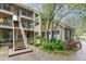 Charming condo exterior with lush landscaping, mature trees, and stairway access at 4713 Spine Rd # D, Boulder, CO 80301