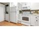 Bright white kitchen with stainless steel appliances and tiled floors, washer/dryer closet at 4713 Spine Rd # D, Boulder, CO 80301
