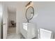 Modern bathroom with a round mirror, white vanity, and sleek fixtures at 2582 S Birch St, Denver, CO 80222