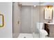 Glass-enclosed shower boasts gold hardware, modern shower head, and beautiful tile at 1317 Monroe St, Denver, CO 80206