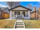 Charming painted brick home with black trim, covered porch, and well-maintained front yard at 1317 Monroe St, Denver, CO 80206