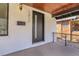 Close-up of the covered front porch highlighting the modern door, stylish number and wooden ceiling at 1317 Monroe St, Denver, CO 80206