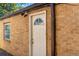 A classic brick house featuring a white back door and a small window at 4685 Wadsworth Blvd, Wheat Ridge, CO 80033