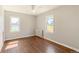 Bright bedroom featuring hardwood floors, two windows with natural light, and a ceiling fan at 4685 Wadsworth Blvd, Wheat Ridge, CO 80033