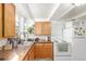 Functional kitchen featuring stainless steel sink, wooden cabinets, and a white refrigerator and stove at 4685 Wadsworth Blvd, Wheat Ridge, CO 80033