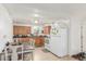 This cozy kitchen has wood cabinets, white appliances, and a dining area at 4685 Wadsworth Blvd, Wheat Ridge, CO 80033